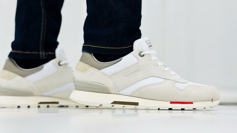 Sneakers en daim beige portées avec un jean, vue de profil au sol