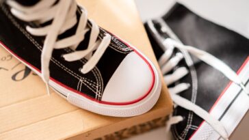 Sneakers en toile neuves posées sur leur boîte en carton