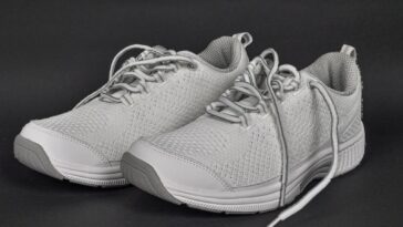 Paire de sneakers grises en maille photographiées de trois quarts