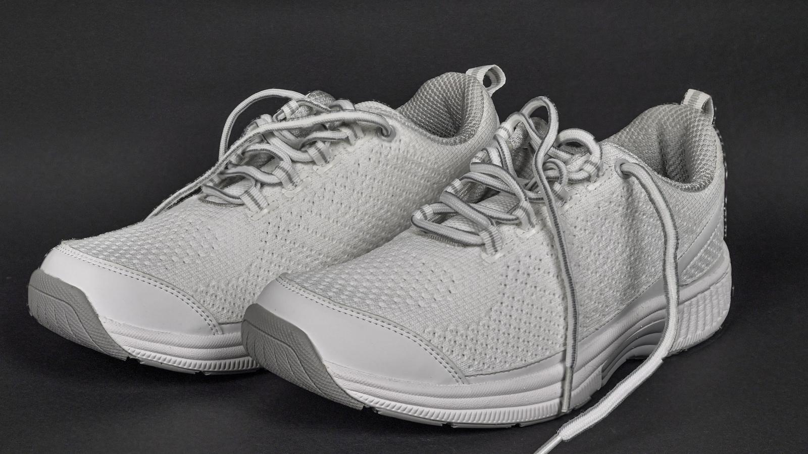 Paire de sneakers grises en maille photographiées de trois quarts