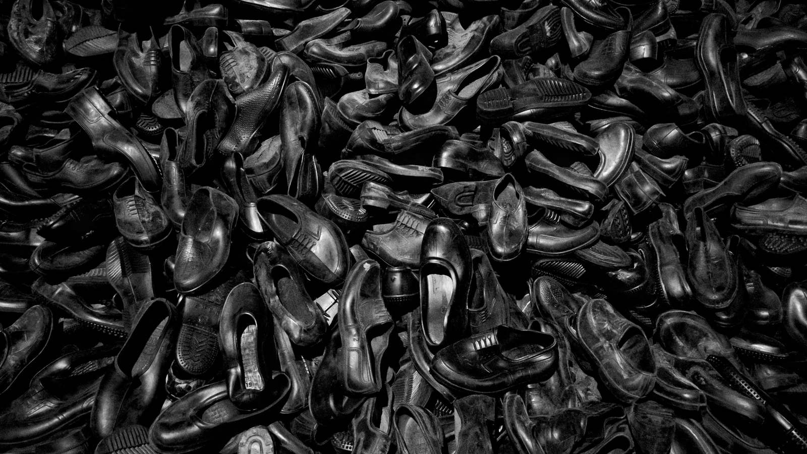 Amoncellement de chaussures photographié en noir et blanc