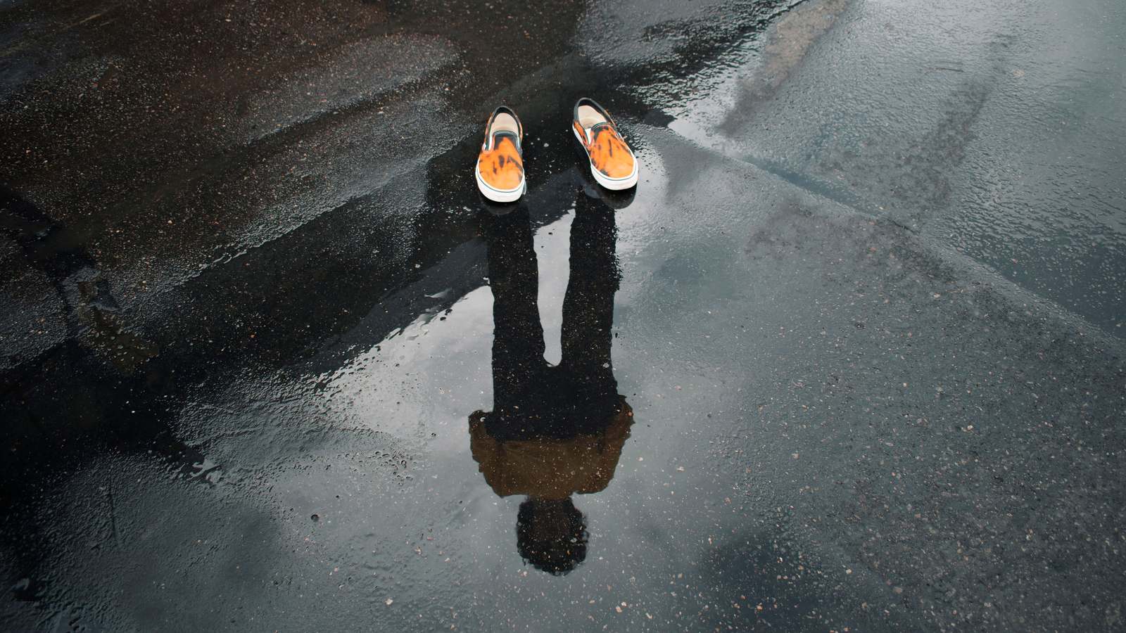 Paire de sneakers vue du dessus sur un sol mouillé avec reflet