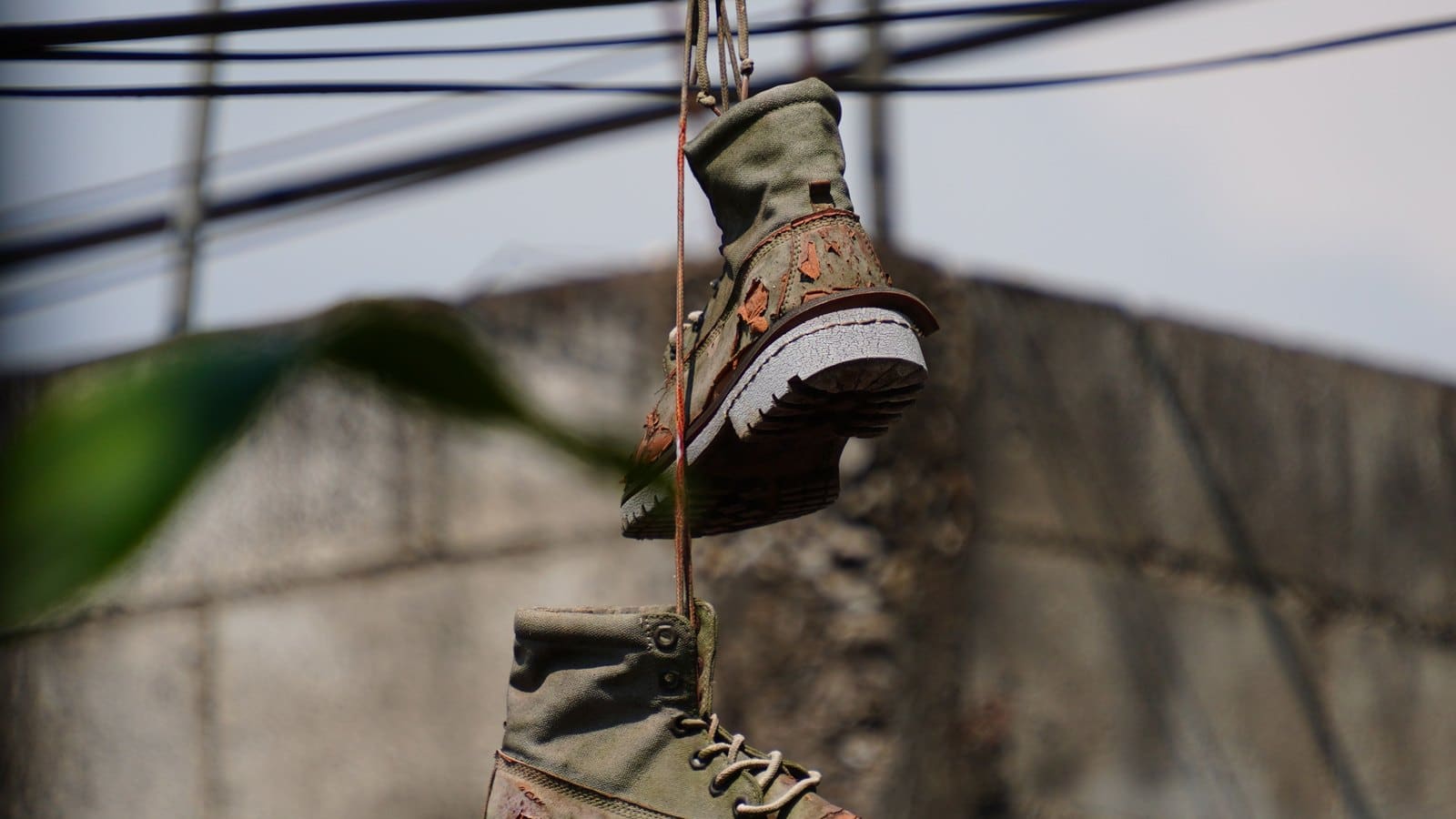 Chaussure suspendue à un câble électrique en extérieur