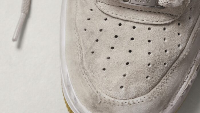 Gros plan sur l'avant-pied perforé en daim beige d'une basket Nike SB Air Force 1